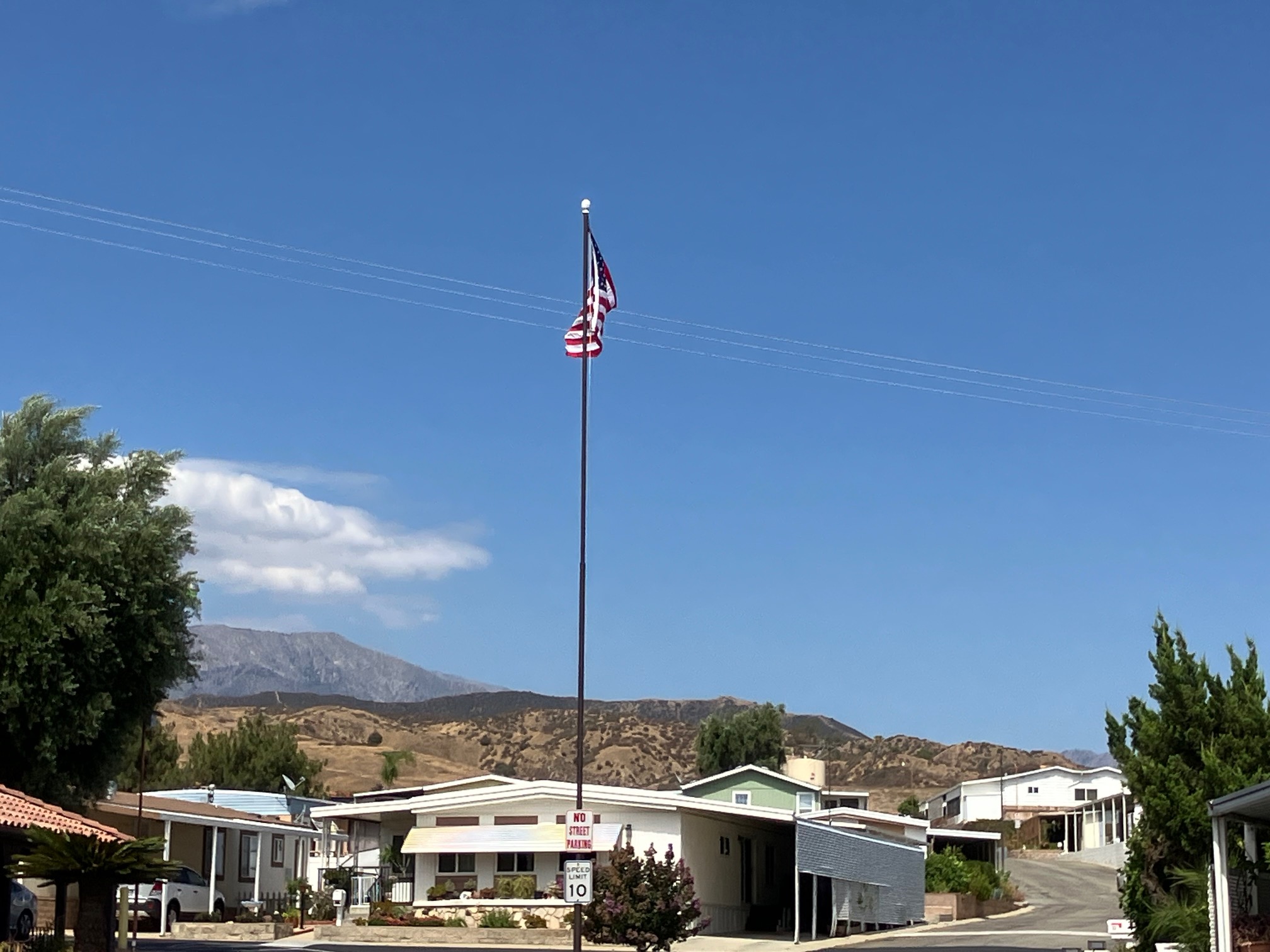 The flagpole and a street of homes with the mountains beyond