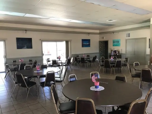 The clubhouse dining hall, round tables set for a gathering
